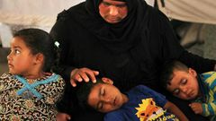 Salima, a 36-year-old mother of four living in the Laylan 2 displacement camp, sits with her children in their tent at the camp, southeast of Kirkuk in northern Iraq