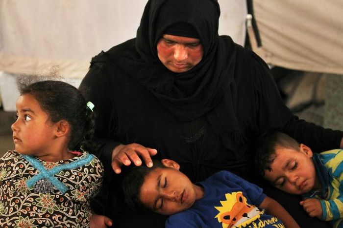 Salima, a 36-year-old mother of four living in the Laylan 2 displacement camp, sits with her children in their tent at the camp, southeast of Kirkuk in northern Iraq