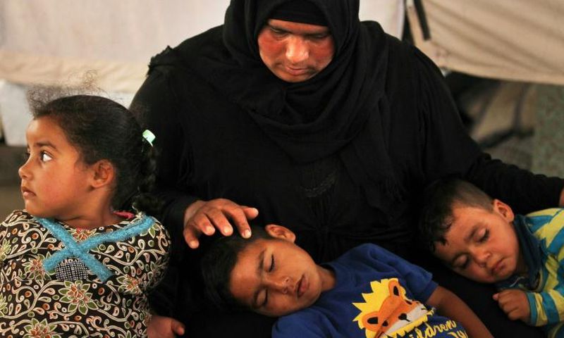 Salima, a 36-year-old mother of four living in the Laylan 2 displacement camp, sits with her children in their tent at the camp, southeast of Kirkuk in northern Iraq