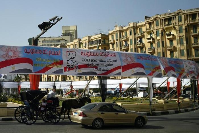 Egyptians pass under banners reading in Arabic "Do what is right" and "Participation is your responsibility", urging voters to vote in the referendum on constitutional amendments