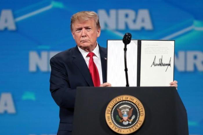US President Donald Trump shows a signed order rejecting the UN Arms Trade Treaty at the Annual National Rifle Association convention
