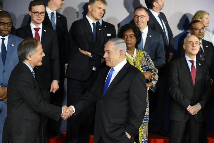 Israeli Prime Minister Benjamin Netanyahu greets participants before a dinner at a conference in Warsaw on the Middle East