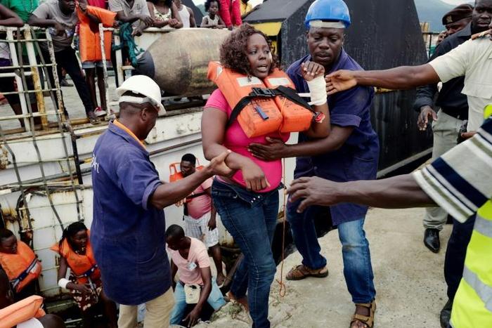 Rescued passengers are disembarked from a rescue vessel at the port of Santo Antonio on Principe after a passenger ship sank