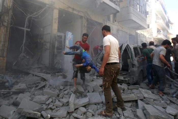 A man evacuates a young casualty following a reported air strike by regime forces and their allies in the jihadist-held Syrian town of Maaret Al-Numan in Idlib province on Sunday