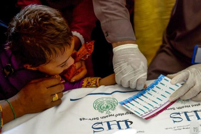 A Pakistani paramedic takes blood samples from a child for a HIV test in Larkana. Nearly 700 people, many of them children, have tested positive in recent weeks