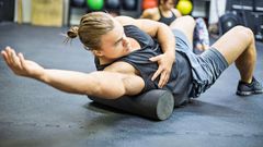 Man exercising on foam roller in gym