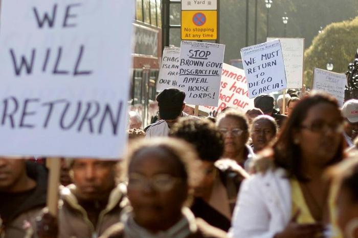 Chagos Islanders leave London's Houses of Parliament with protest signs on October 22, 2008
