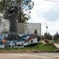 A portrait of Syrian President Bashar al-Assad stands near a sculpture in the Syrian town of Quneitra, in the Golan Heights