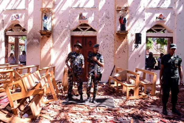 Sri Lankan soldiers keep watch in badly damaged St. Sebastian's Church in the city of Negombo on April 21, 2019, following a series of bomb blasts that killed more than 200, including many foreigners