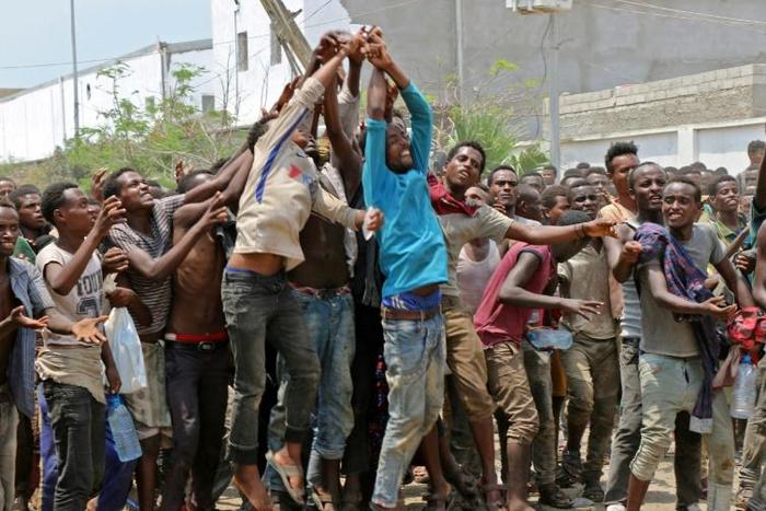 African migrants receive food and water inside a football stadium in the Red Sea port city of Aden in Yemen, on April 23, 2019