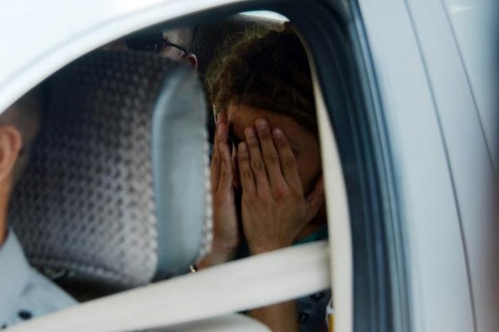 French tourist Arthur Desclaux covers his face while leaving in a police car after a court appearance in Naypyidaw. On Wednesday he was been sentenced to one month in prison with hard labour for attempting to fly a drone near Myanmar's parliament