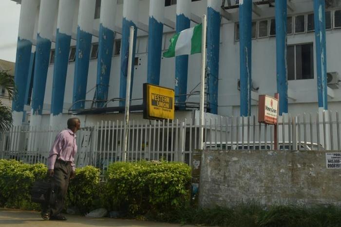 A man walk past a Western Union money transfer and Moneygram in Benin City, Nigeria