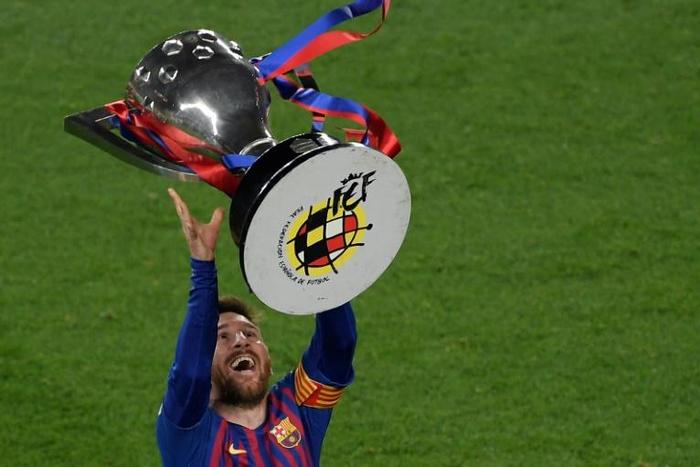 Lionel Messi raises aloft the trophy after Barcelona clinched another Spanish title on Saturday
