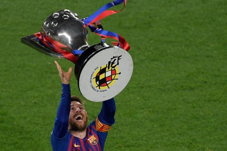 Lionel Messi raises aloft the trophy after Barcelona clinched another Spanish title on Saturday