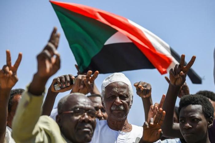 Sudanese protesters chant slogans, flash V-for-victory signs and wave the national flag at the sit-in outside the army headquarters in the capital Khartoum on May 14, 2019