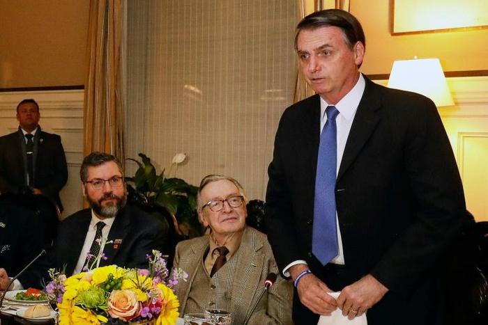 Brazilian President Jair Bolsonaro (R) with his firebrand right-wing "guru" Olavo de Carvalho (C) and Foreign Minister Ernesto Araujo (L) in a meeting at Brazil's embassy in Washington