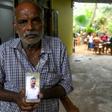 Velusami Raju with a photo of his son Ramesh, who died after he stopped an attacker at the door of the Zion church in Batticaloa