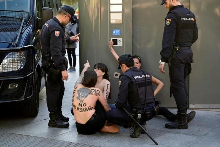 With the anti-Franco slogan "They shall not pass" daubed on their naked breasts, three of the femenist activists got on stage at the capital's Columbus Square before the arrival of Vox leader Santiago Abascal
