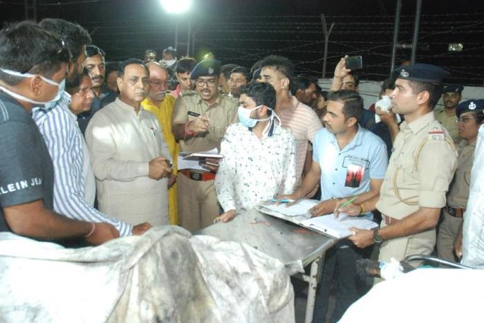 Gujarat Chief Minister Vijaybhai Rupani stands near the bodies of students who died in the fire in Surat