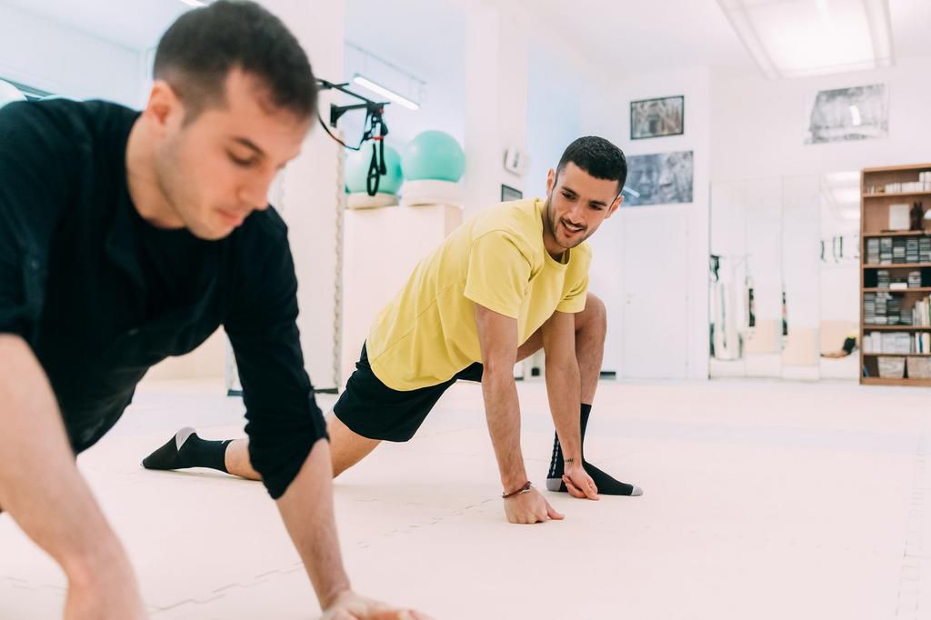 Men in gym doing stretching exercises