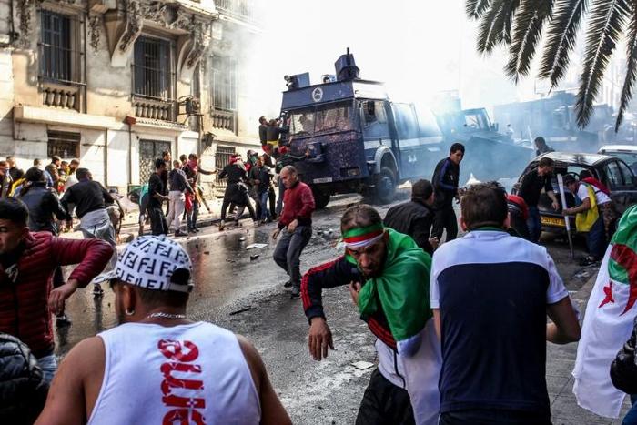 Members of the Algerian riot police clash with protesters as they try to disperse them during an anti-government demonstration in the capital Algiers