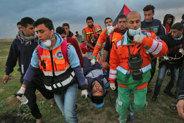 Palestinian paramedics carry a protester injured in a demonstration along the Gaza-Israel border on March 1, 2019