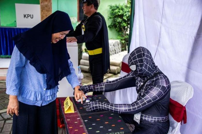 Election officials dressed as cartoon superheroes in Surabaya to encourage voters to come to the polling station