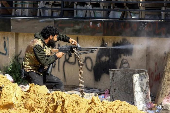 A Libyan fighter from the UN-recognised Government of National Accord fires a machinegun during clashes with forces loyal to strongman Khalifa Haftar south of the capital Tripoli's suburb of Ain Zara on April 10, 2019