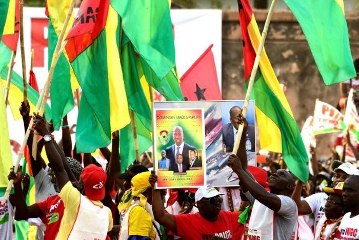 Activists of the African Party for the Independence of Guinea and Cape Verde (PAIGC) hold a picture of Guinea-Bissau's party leader Domingos Simoes Pereira during a rally in March 2019