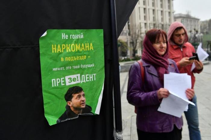 Party suporters hand out leaflets to passersby outside of the incumbent President Petro Poroshenko's campaigning tent, decorated with signs that read 'Stop' or 'Ze', a pun on the name of rival candidate comedian Volodymyr Zelensky