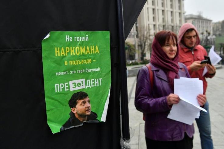 Party suporters hand out leaflets to passersby outside of the incumbent President Petro Poroshenko's campaigning tent, decorated with signs that read 'Stop' or 'Ze', a pun on the name of rival candidate comedian Volodymyr Zelensky