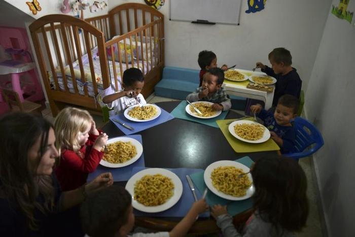 Children eat at the Kapuy Foundation shelter -which supports children in situation of abandonment or with serious health problems, including undernourishment- in Maracay, Aragua state, Venezuela