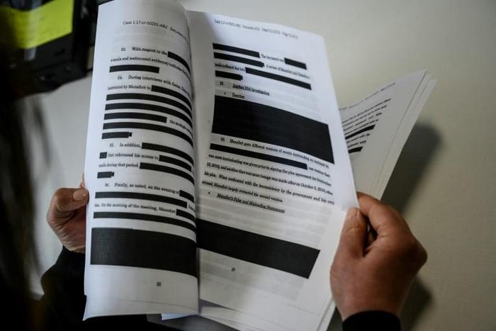 A journalist reads a redacted court filing from Special Council Robert Mueller; many worry that key parts of his final report will be similarly censored
