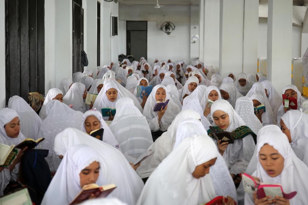 Muslim students from Ar-Raudlatul Hasanah boarding school read Koran during the first day of the holy fasting month of Ramadan at a mosque in Medan