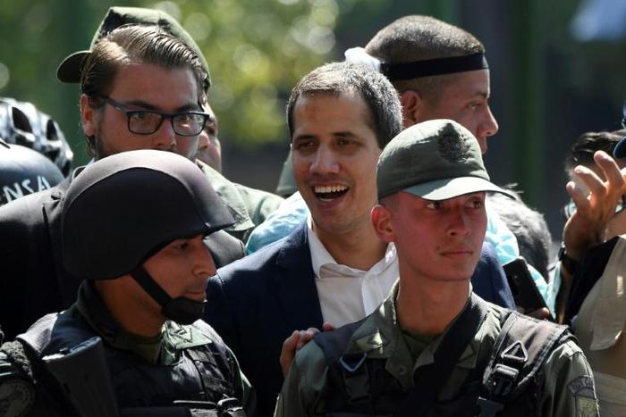 A Brazilian official confirmed there had been "various applications" from Venezuelan soldiers for asylum in the embassy in Caracas after self-declared president Juan Guaido (C) claimed soldiers had joined him