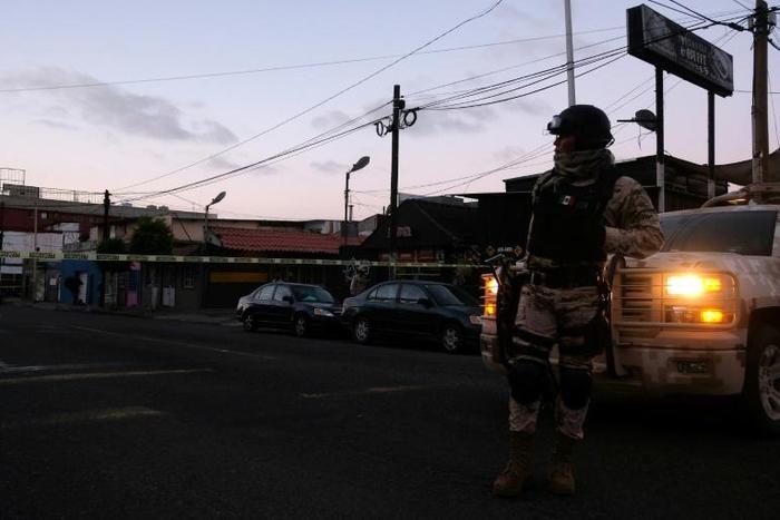 Mexican soldiers guard a crime scene where a man was killed by gunfire in downtown Tijuana, one of many cities riven by drug cartel violence in the country