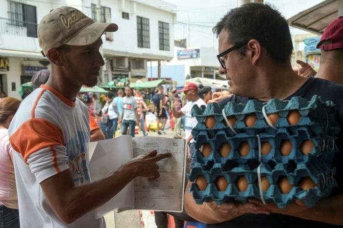 Giovanni Jose Plaza (L), a Venezuelan migrant suffering from AIDS, asks passersby in the border town of Cucuta, Colombia for money to buy medications