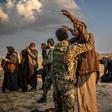 Men suspected of being Islamic State group fighters are searched after leaving the jihadists' last holdout of Baghouz in Syria