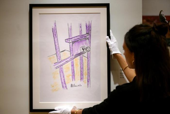 A worker at Bonhams auction house holds a sketch by Nelson Mandela -- "The Cell Door, Robben Island" -- in New York, where it will go up for sale on May 2, 2019