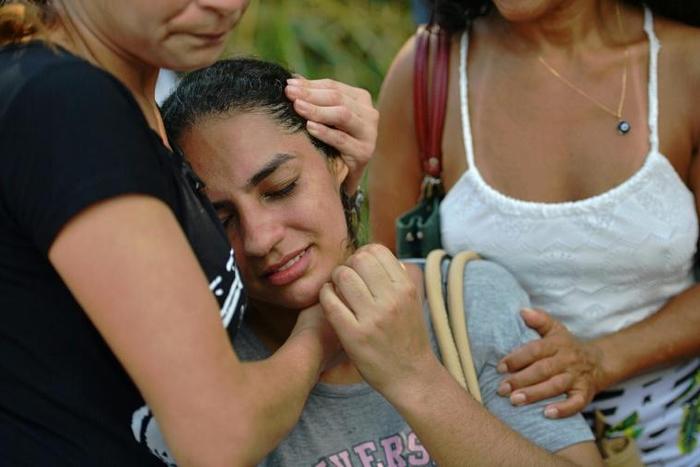 A woman is comforted after two buildings collapsed in the Muzema favela of Rio de Janeiro, Brazil, on April 12, 2019