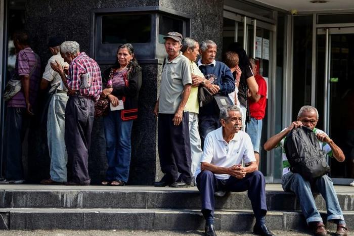 Venezuela's international banking under sanctions pressure: elderly people waiting for their pension monthly payment outside a bank in Caracas
