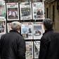 Algerians look at the headlines of newspapers at a kiosk in the capital Algiers on February 11, 2019