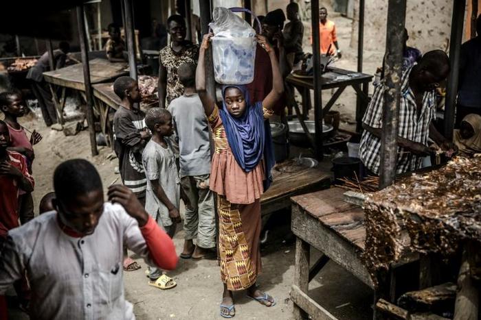 A girl selling water waits for costumers at a market, which was attacked last year by Boko Haram Islamists, in the Nigerian city of Mubi