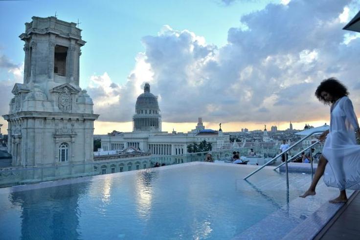A tourist stands by the rooftop swimming pool at the Gran Hotel Manzana in Havana -- one of many luxury properties attracting tourists in Cuba