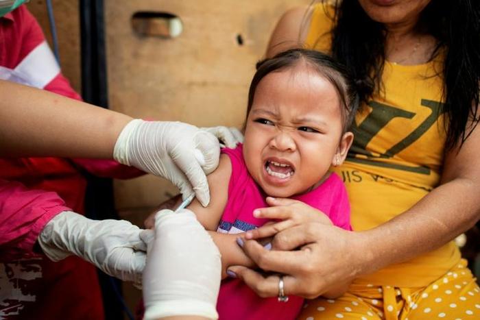 A child reacts during a Philippine Read Cross Measles Outbreak Vaccination Response in Manila on February 16, 2019