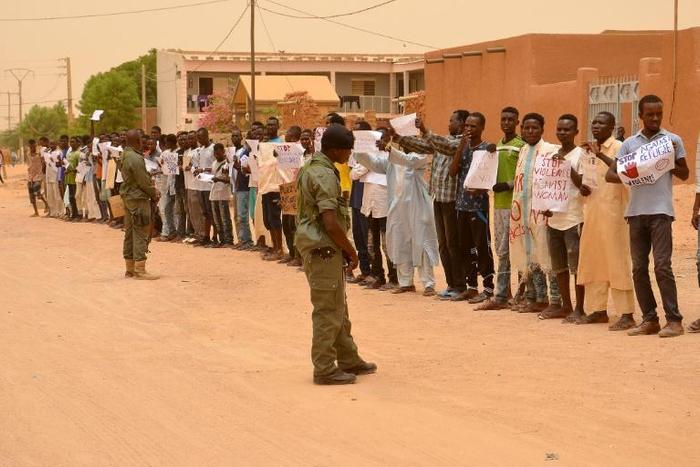 Migrants hold up banners to protest violence against refugees as UN refugee chief Filippo Grandi visits Agadez last June