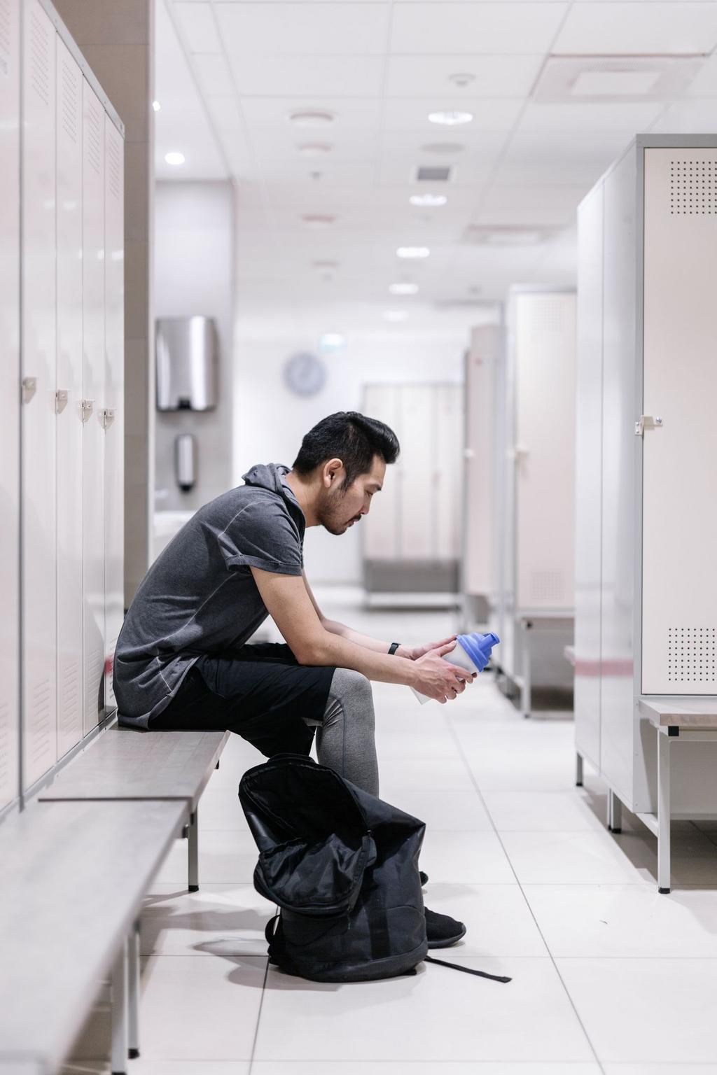Tired japanese man in the locker room