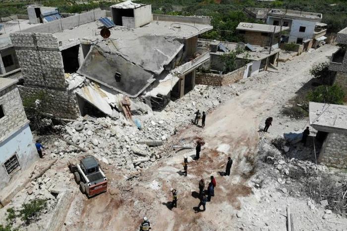 Members of the Syrian Civil Defence (White Helmets) clear rubble to open a road following reported shelling on the village of Ibdita in the Idlib province on May 8, 2019