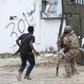 Fighters loyal to Libya's Government of National Accord carry a wounded man, as clashes rage south of the capital Tripoli