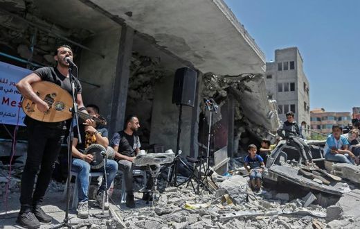 The Palestinian band Dawaween performs on May 14, 2019 on the rubble of a building in the Gaza Strip that was recently destroyed by Israeli air strikes during an event calling for a boycott of the Eurovision song contest hosted by Israel